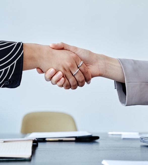 Minimal,Closeup,Of,Two,Business,Women,Shaking,Hands,Over,Meeting