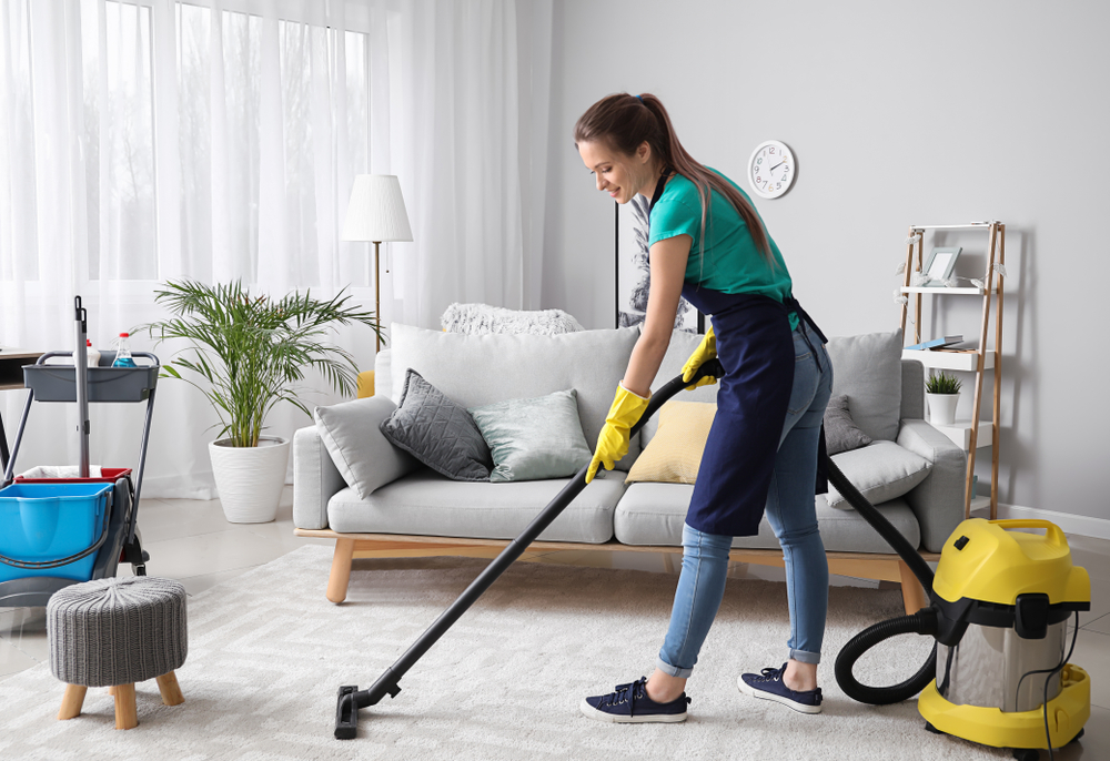 Female,Janitor,With,Vacuum,Cleaner,In,Room